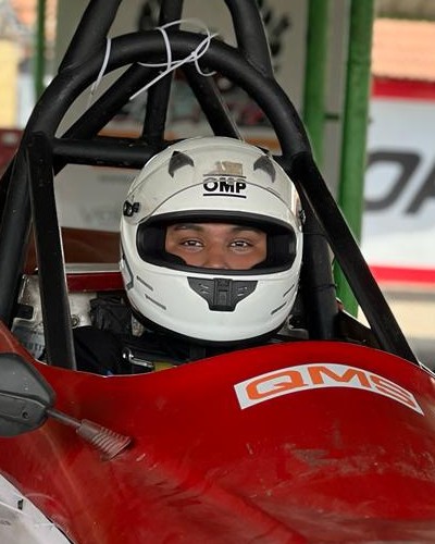 Senaajit in his helmet, sitting in the cockpit of his red number 15 race car